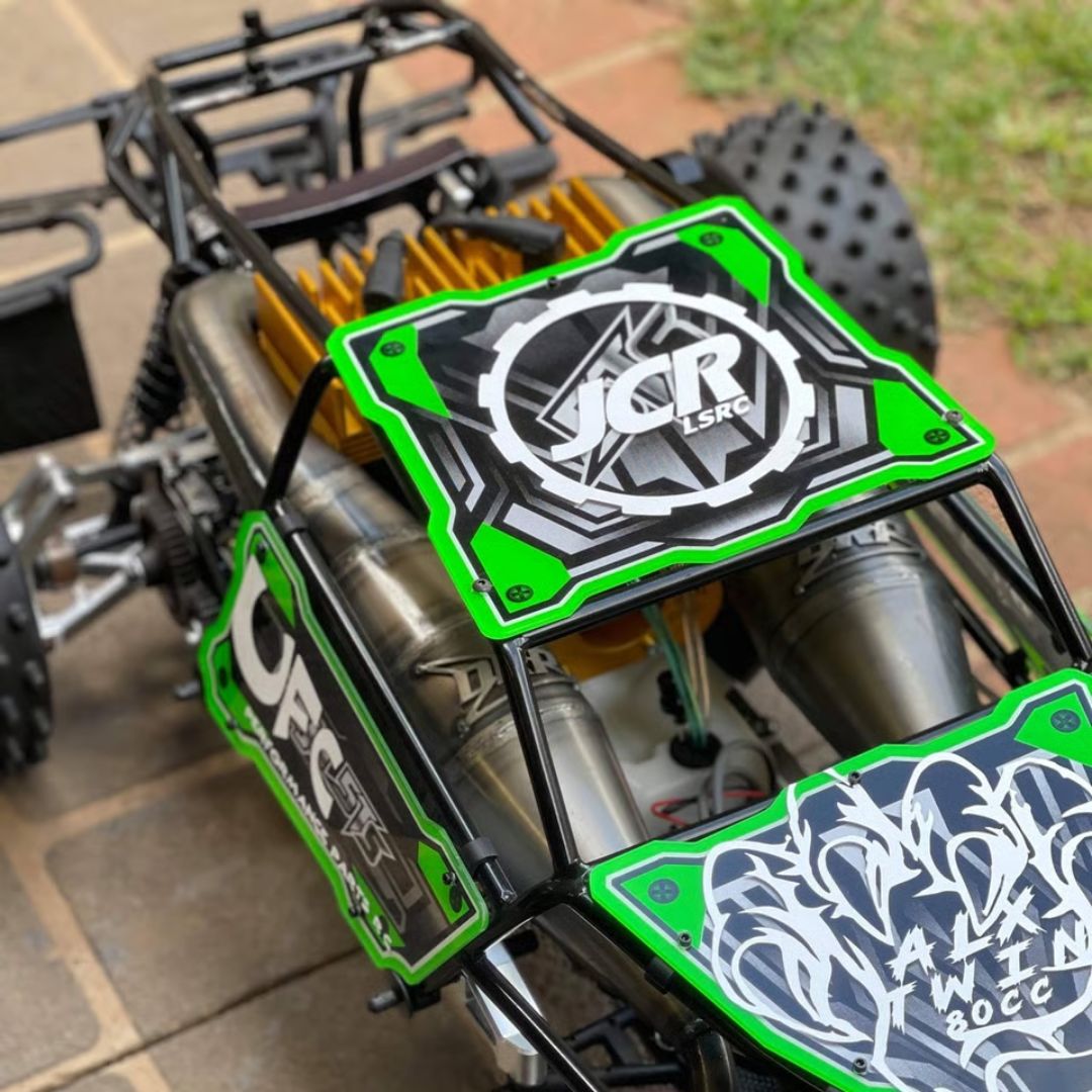 Close-up of a green and black RC car with visible branding on a tiled floor.