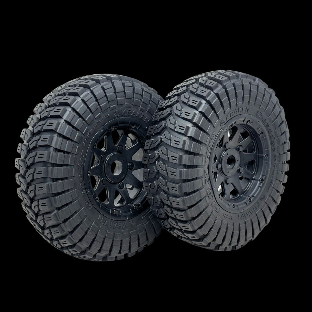 Two black off-road tires with tread patterns on a transparent background