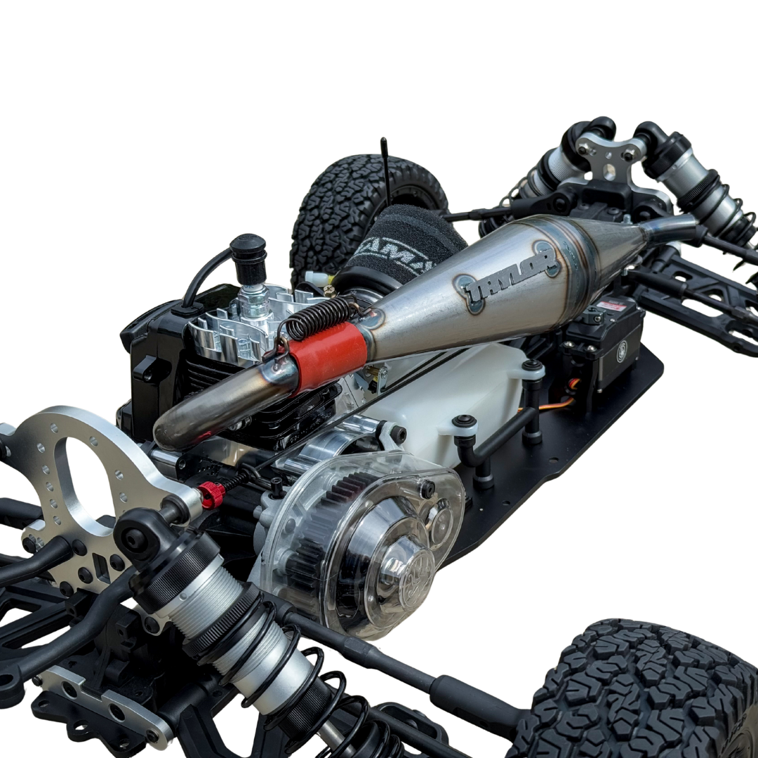 Close-up of a detailed RC car chassis with suspension and engine components on a white background