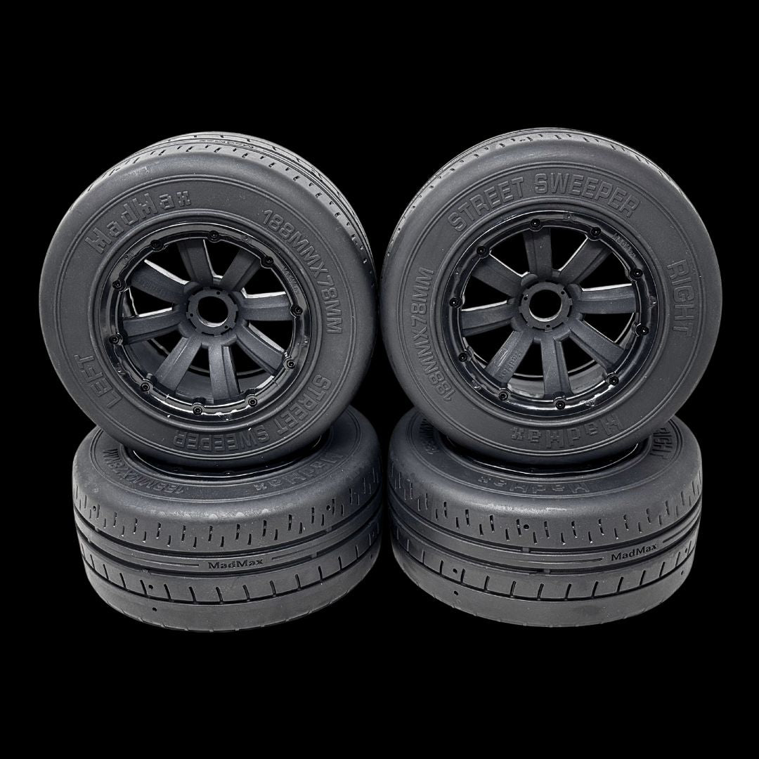 Four black model car wheels with detailed treads on a transparent background