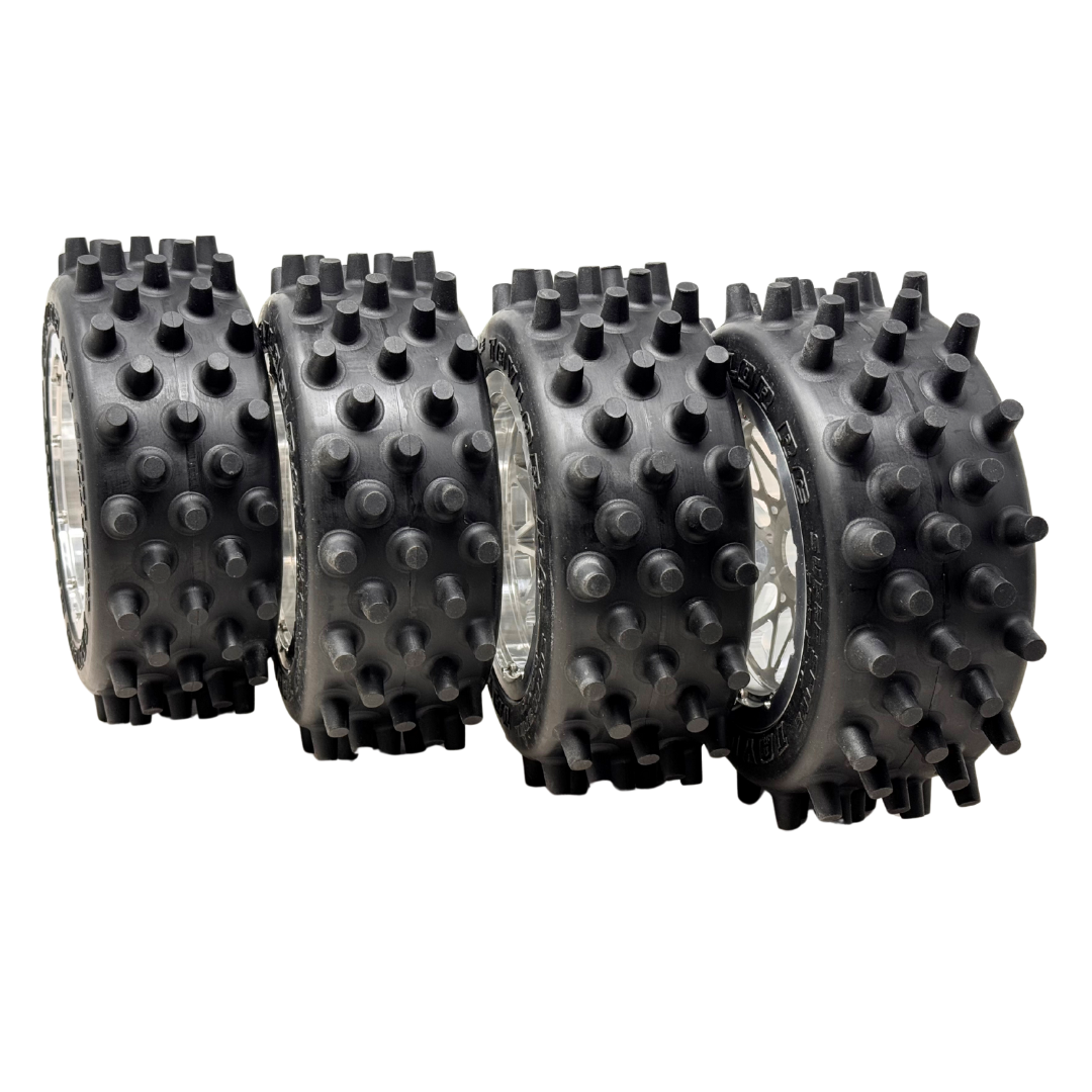Four black spiked wheels on a white background