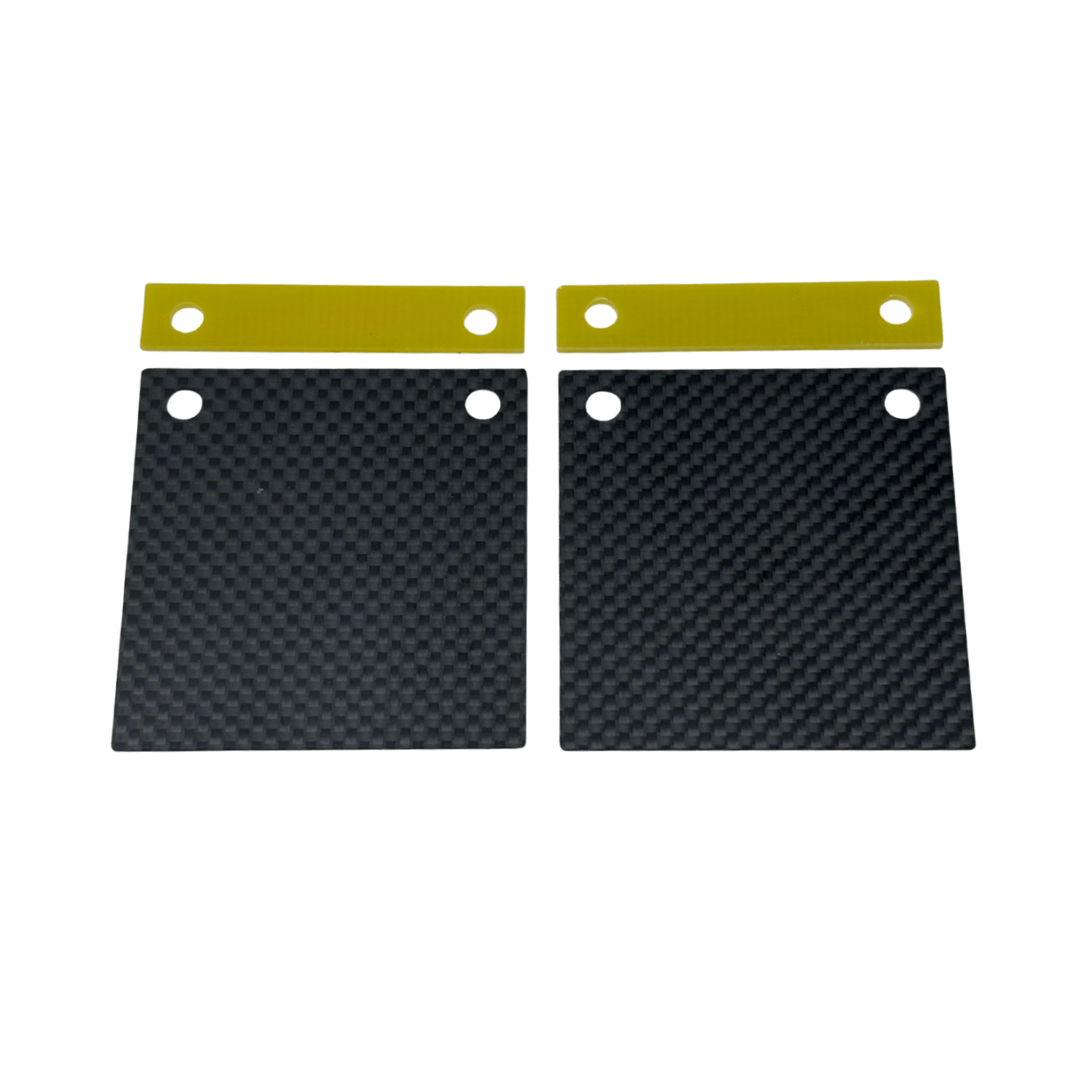 Two black carbon fiber plates with gold straps on a white background