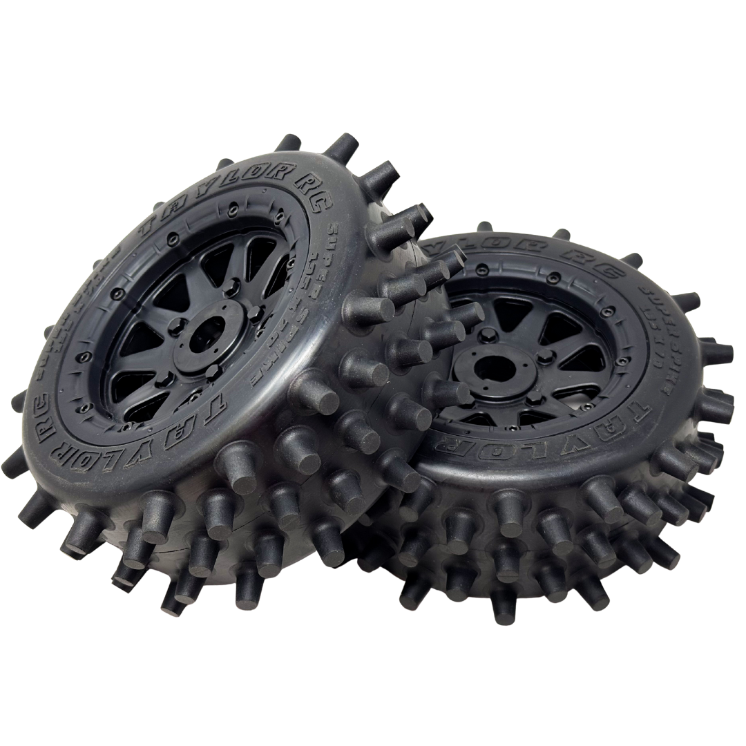Two black off-road wheels with spiky tread pattern on a white background