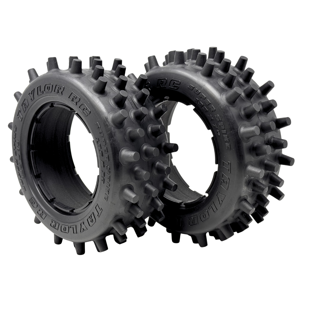 Two black tires with spiky tread pattern on a white background