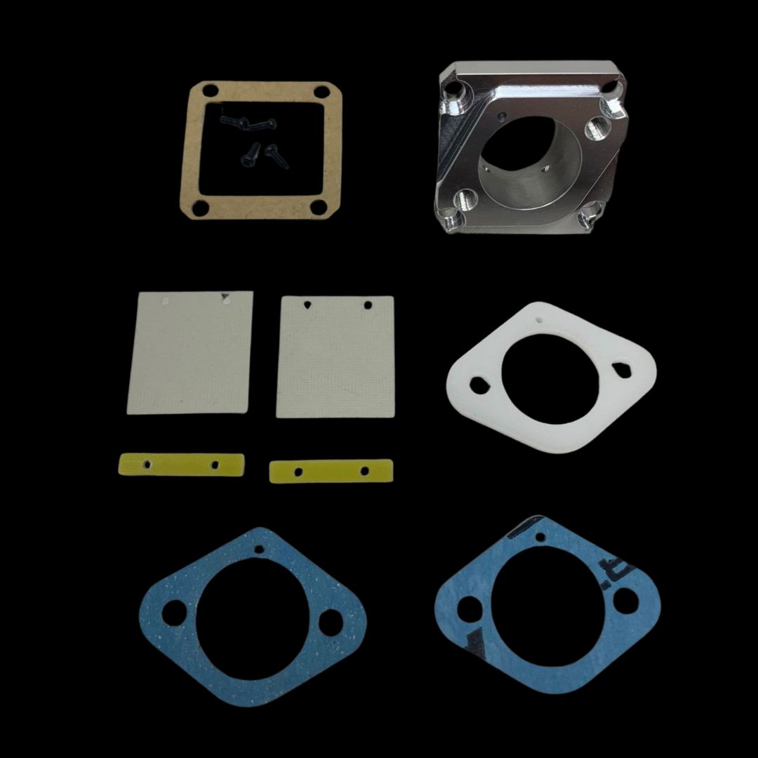 A set of metal and rubber parts for a Taylor 35cc engine reed valve kit, including gaskets and mounting brackets.