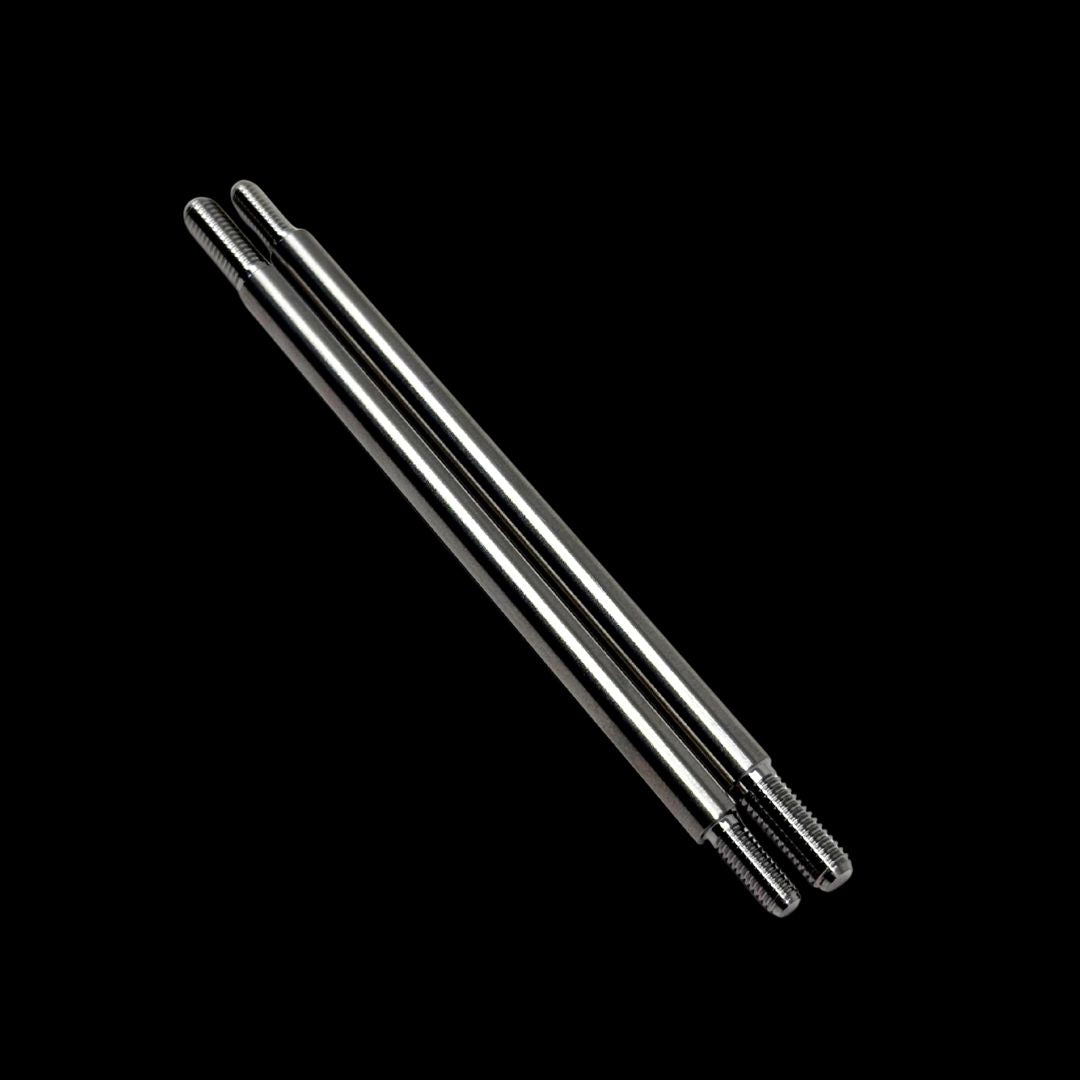 Two titanium mcd shock shafts on a black background