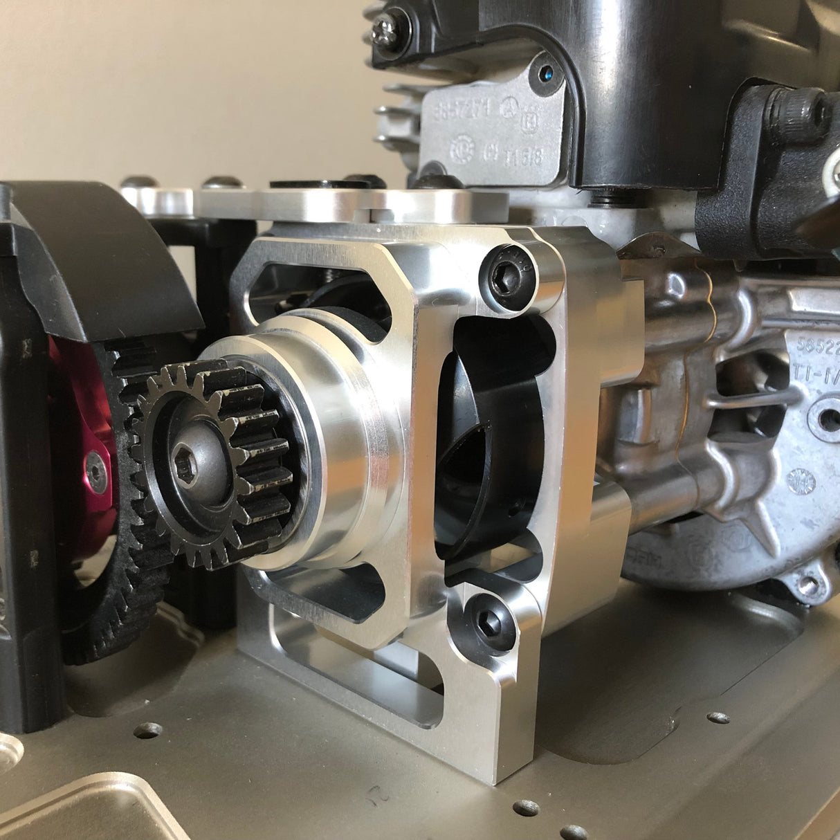 Metal clutch carrier for remote control vehicles, showing a vented design with multiple openings and a polished metallic finish.