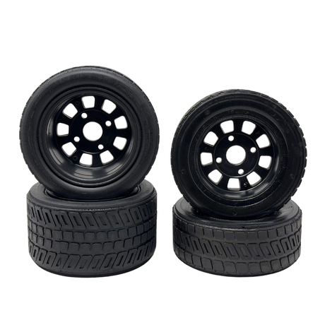 Four black wheels with tread patterns on a white background
