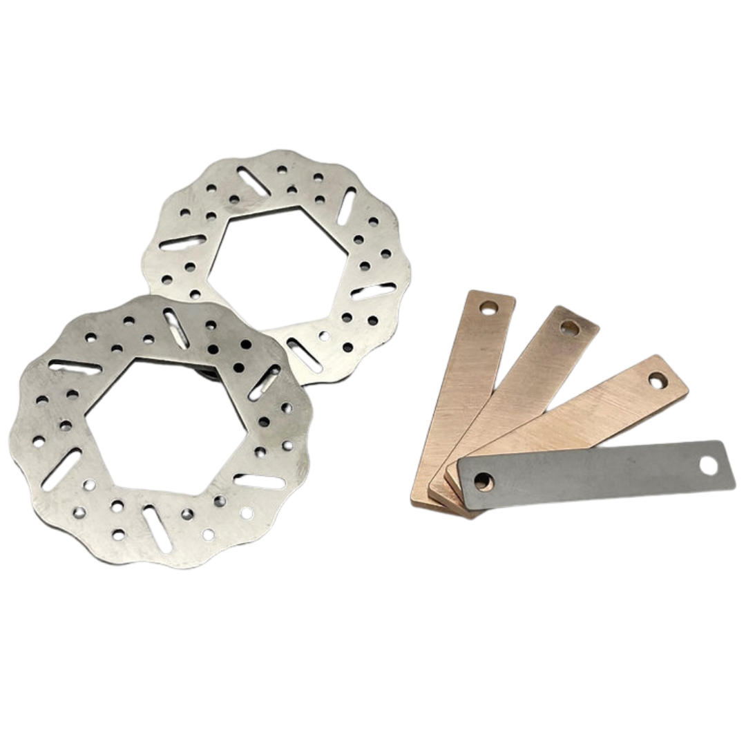 Two metal brake rotors and three metal feeler blades on a white background