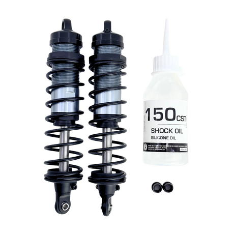 Two shock absorbers and a bottle of shock oil on a white background
