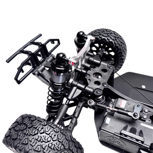 Close-up of a detailed model vehicle chassis with suspension and tires on a white background