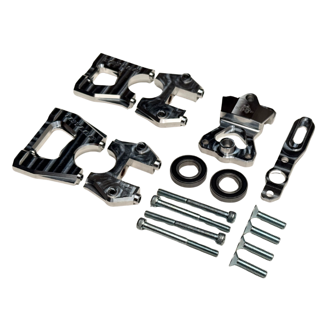 Taylor Losi 5ive-TG 3.0 centre diff mount kit components at an angle, showing ribbed black anodised halves, raw silver top plate, bearings and hardware