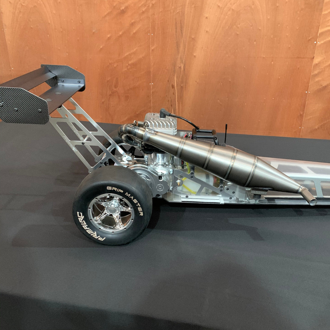 A Primal Dragster engine package, featuring a billet reed engine and custom GT triple exhaust port cylinder, primarily in metallic colors.