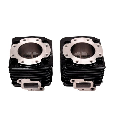 Two black and silver engine cylinder heads on a white background