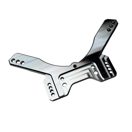 Taylor RC OUTLAW drop rear shock tower in raw silver, angled view showing the shock mounting holes, arm slots, and central chassis clearance cutout