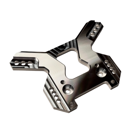 Taylor RC OUTLAW V4 front shock tower in raw silver, angled view from the opposite side showing the shock mounting holes and arm slots