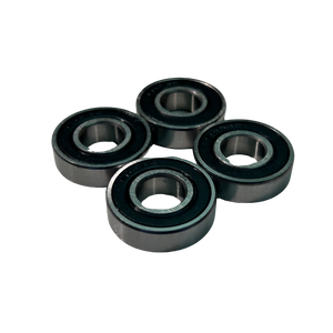 Four black cylindrical bearings on a white background
